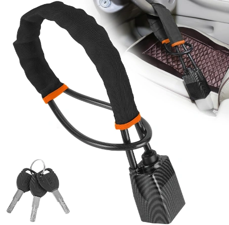 CarProtect cable lock with its two keys, resting on a car seat beside the seatbelt buckle